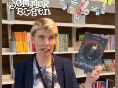 Signe der står med en bog